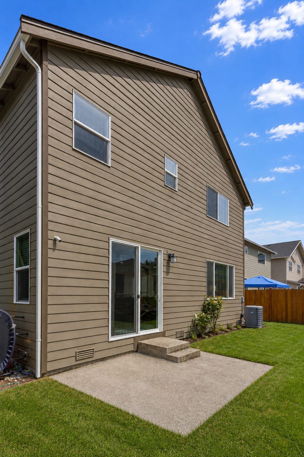Backyard with concrete patio and fenced lawn